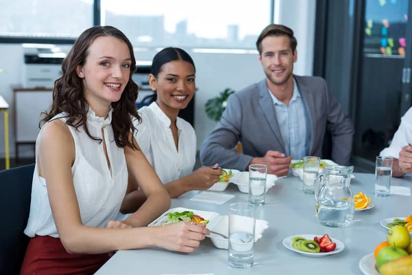 Ejecutivos de negocios sonrientes comiendo en la oficina —  Fotos de Stock