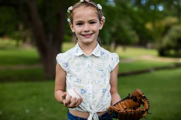 Χαριτωμένο κορίτσι εκμετάλλευση μπέιζμπολ στο πάρκο — Φωτογραφία Αρχείου