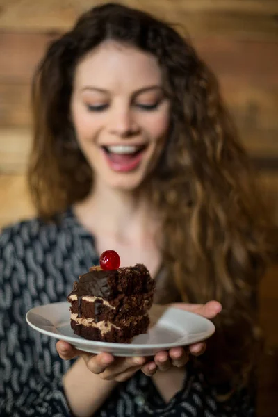 Mujer sosteniendo un plato de pastelería en la cafetería —  Fotos de Stock