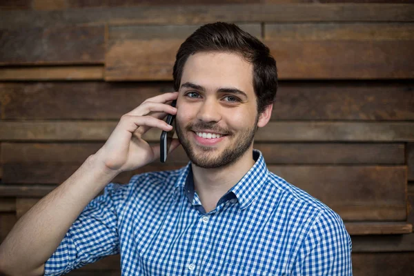 Ejecutivo sonriente hablando por teléfono móvil en la oficina —  Fotos de Stock