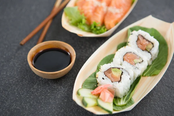 Sushi su piastra a forma di barca con bacchette — Foto Stock