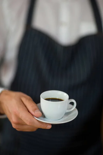 Mid-section of waiter standing with cup of coffee — Stock Photo, Image