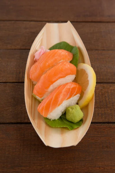 Tres nigiri sushi servidos en plato de barco de madera —  Fotos de Stock