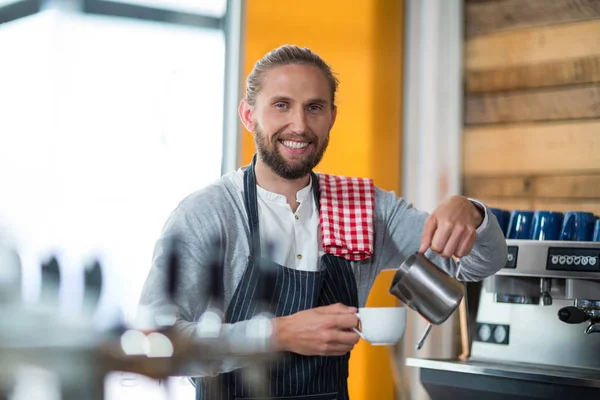 Serveur souriant faisant tasse de café au comptoir dans le café — Photo