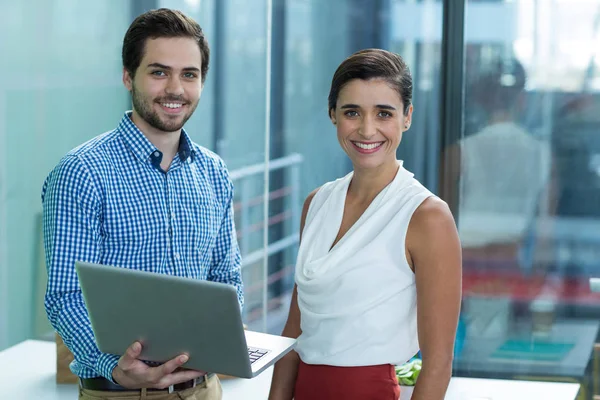 Dirigeants d'entreprise souriants Debout au bureau avec ordinateur portable — Photo