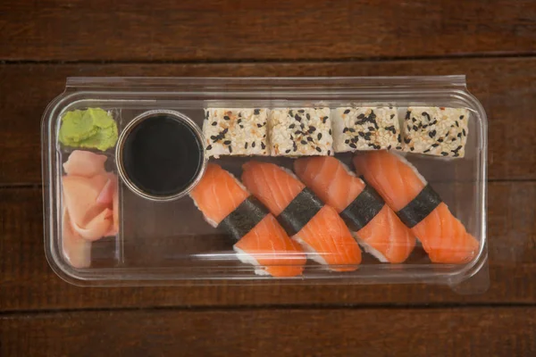 Plastik bir kutu içinde Soya soslu nigiri ve uramaki suşi tuttu — Stok fotoğraf