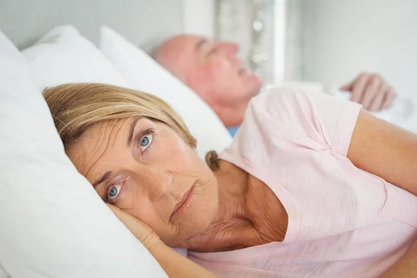 Senior Kvinna vilar på sängen — Stockfoto