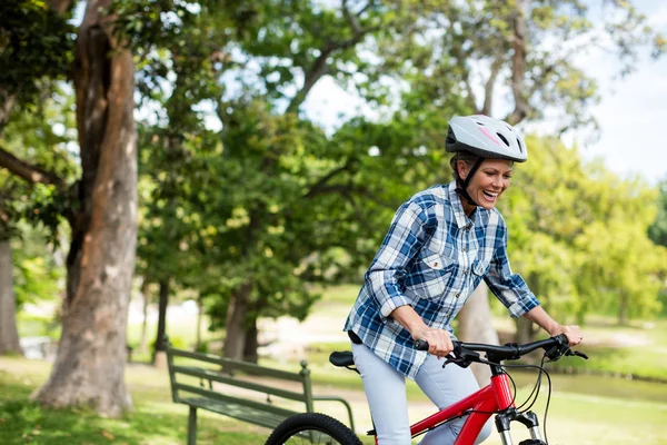 Mujer feliz ciclismo en el parque — Foto de Stock