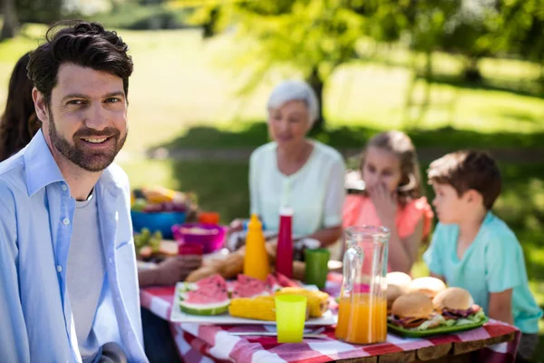 Ritratto di uomo sorridente seduto nel parco — Foto Stock