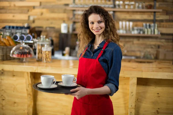 Portret van lachende serveerster permanent met kopje koffie — Stockfoto