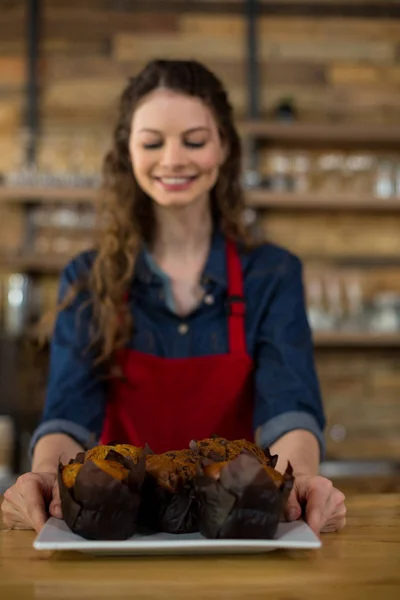 Serveerster serveren een cup cake op teller — Stockfoto