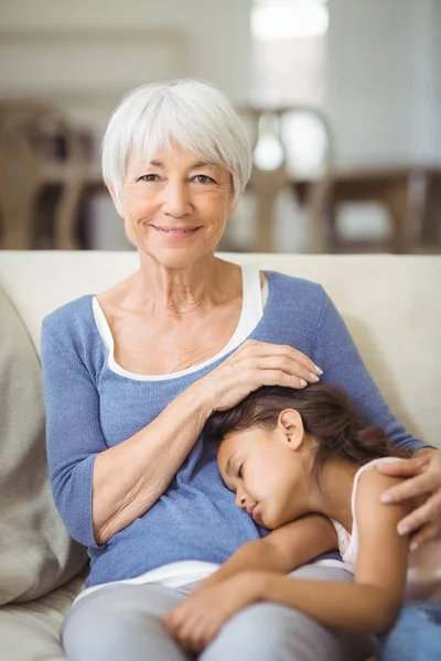 Vnučka spí na klíně babičky v obývacím pokoji — Stock fotografie