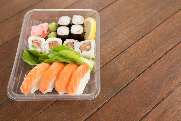 Conjunto de sushi variado servido em uma caixa de plástico — Fotografia de Stock