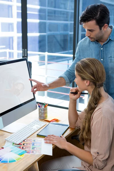 Diseñador gráfico trabajando en el escritorio con su colega —  Fotos de Stock