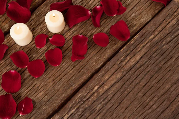 Воскові свічки в оточенні пелюсток троянд — стокове фото