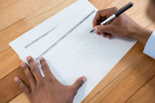 Бізнесмен маркує ручкою на календарі — стокове фото