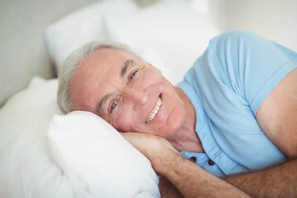 Retrato de homem idoso feliz deitado na cama — Fotografia de Stock