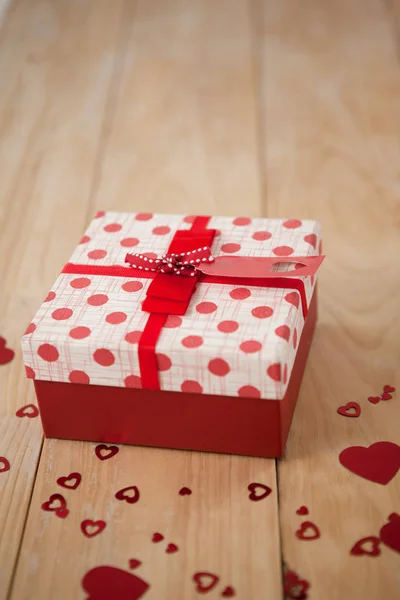 Scatola regalo circondata da decorazione del cuore — Foto Stock