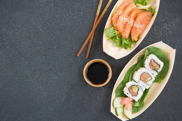 Sushi on boat shaped plate with chopsticks — Stock Photo, Image