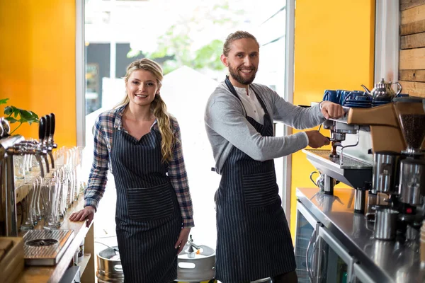 Porträtt av leende servitris och servitör arbetar på counter — Stockfoto