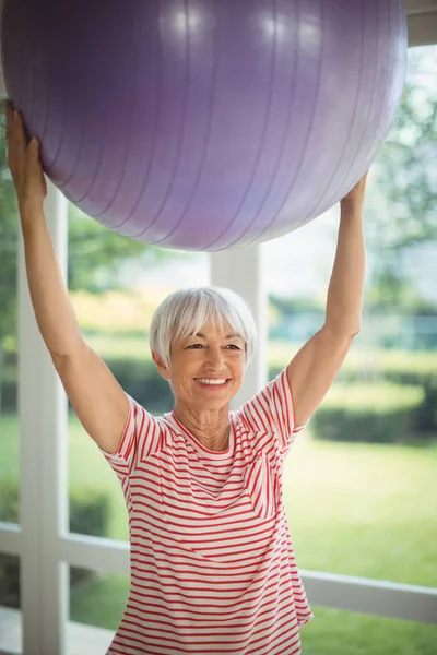 फिटनेस चेंडूसह व्यायाम करणारी वरिष्ठ स्त्री — स्टॉक फोटो, इमेज