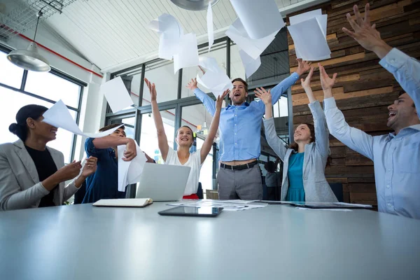 Team of graphic designers throwing documents up in air — Stock Photo, Image