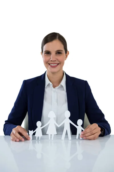 Smiling businesswoman holding paper cut out of family — Stock Photo, Image