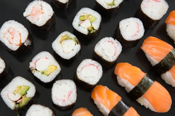 Olika sushi på svart bakgrund — Stockfoto