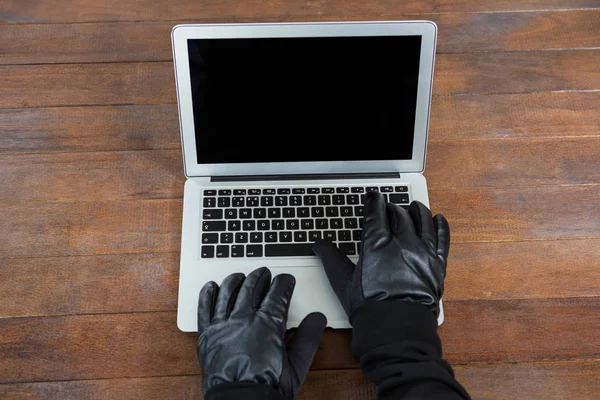 黑客在桌子上使用笔记本电脑 — 图库照片