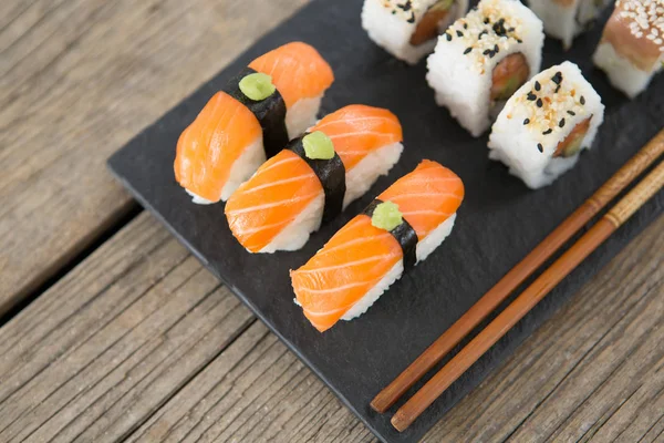 Conjunto de sushi variado servido em ardósia de pedra preta — Fotografia de Stock