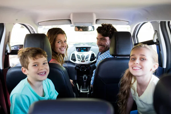 Familia feliz sentado en el coche — Foto de Stock