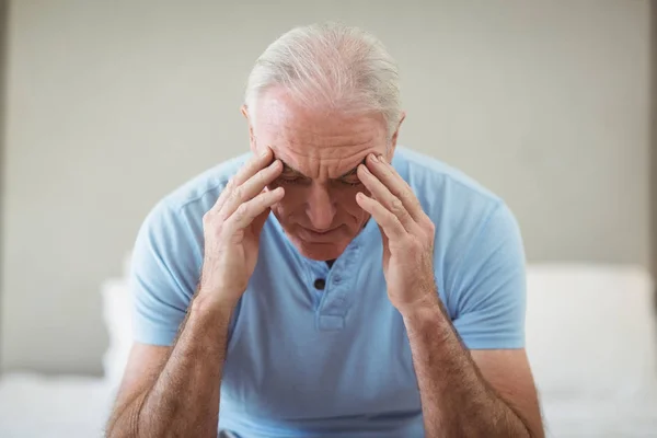 Benadrukt senior man zittend op bed — Stockfoto