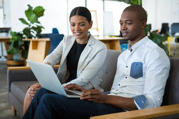 Affärsman och en kollega diskuterar över laptop — Stockfoto