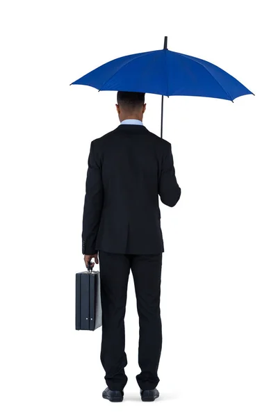 Empresário segurando guarda-chuva azul e uma pasta — Fotografia de Stock