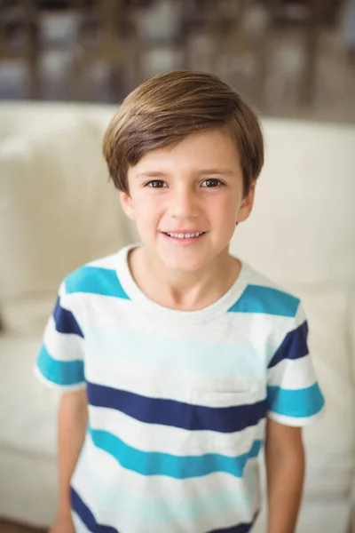 Retrato de niño de pie cerca del sofá en la sala de estar — Foto de Stock