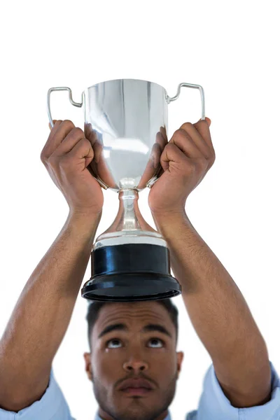 Крупный план бизнесмена, поднимающего трофей — стоковое фото