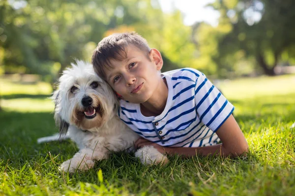 Portrait of boy with dog in park — Stock Photo, Image