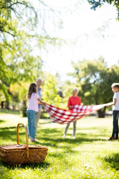 Family placing blanket in park — Stock Photo, Image