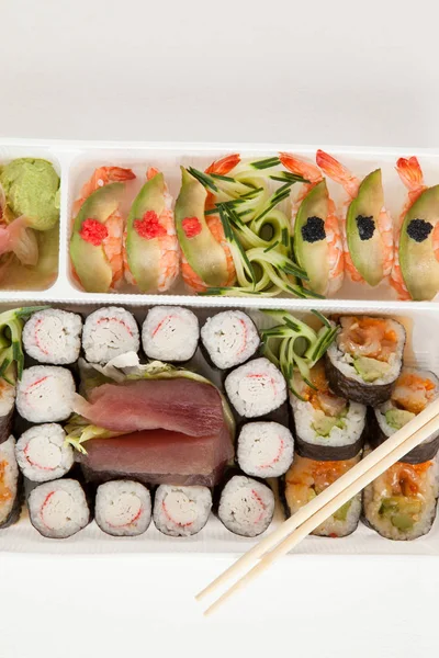 Blandade sushi set serveras med ätpinnar i vit ruta mot vit bakgrund — Stockfoto