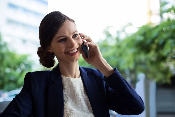 Businesswoman talking on mobile phone in cafe — Stock Photo, Image