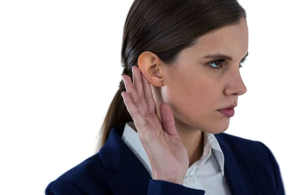 Businesswoman listening with hand on ear — Stock Photo, Image