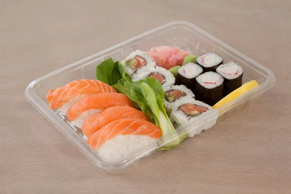 Uppsättning av blandade sushi höll i en plastlåda — Stockfoto