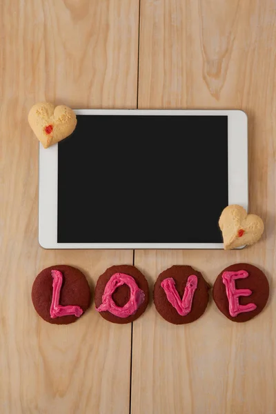 Tablet digital e cookies com mensagem de amor — Fotografia de Stock