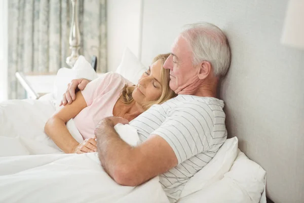 Coppia anziana che abbraccia sul letto — Foto Stock