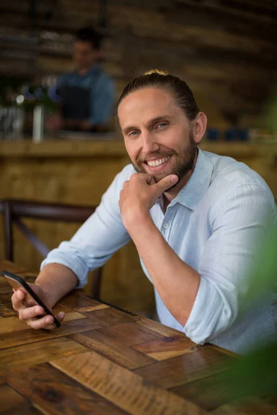 Mosolygó ember használ mozgatható telefon kávézóban — Stock Fotó