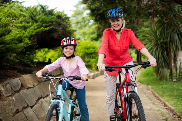 Oma en kleindochter fietsen in park — Stockfoto