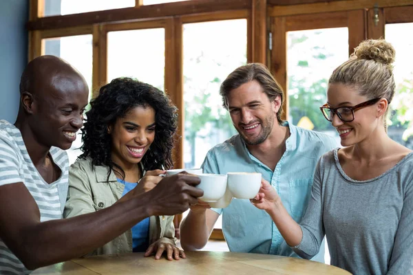 Amigos felices tostando taza de café en la cafetería —  Fotos de Stock