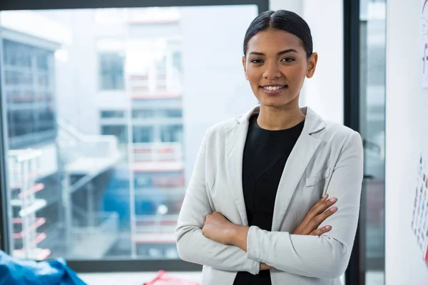 Retrato de mujer de negocios sonriente de pie con los brazos cruzados — Foto de Stock