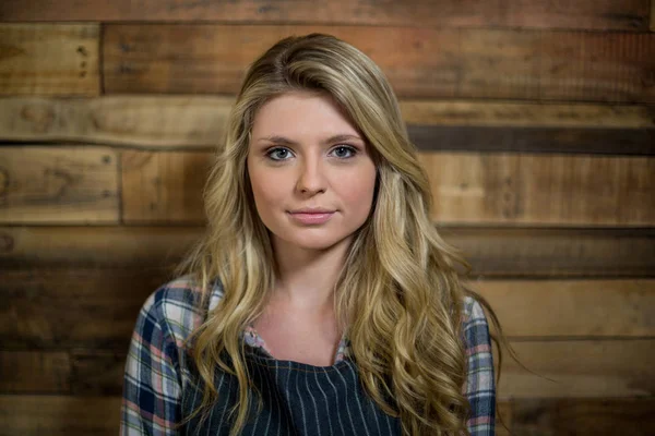 Portrait of waitress standing against wooden wall — Stock Photo, Image