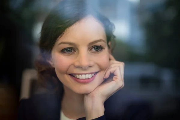 Femme d'affaires réfléchie souriant dans un café — Photo